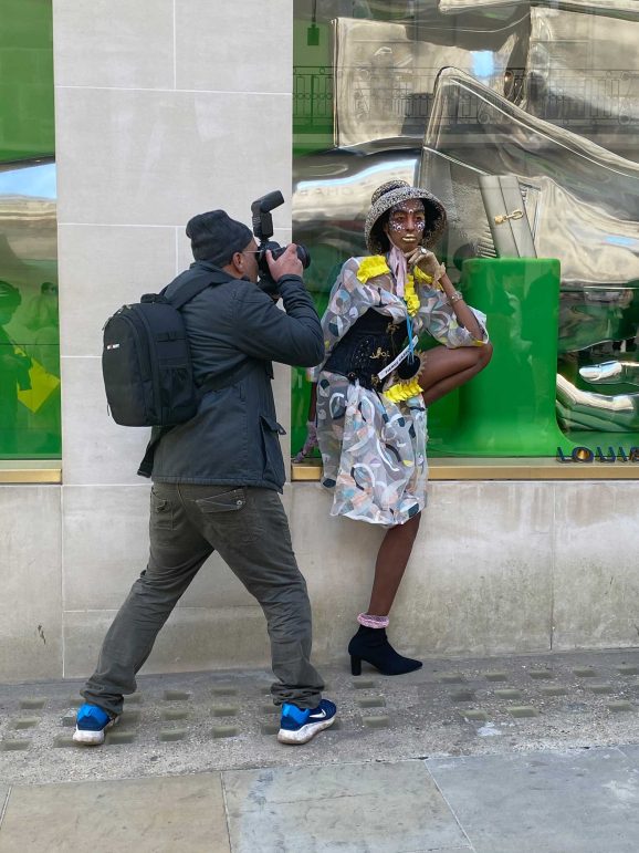 A photograph of a Paparazzi closely photographing a model.