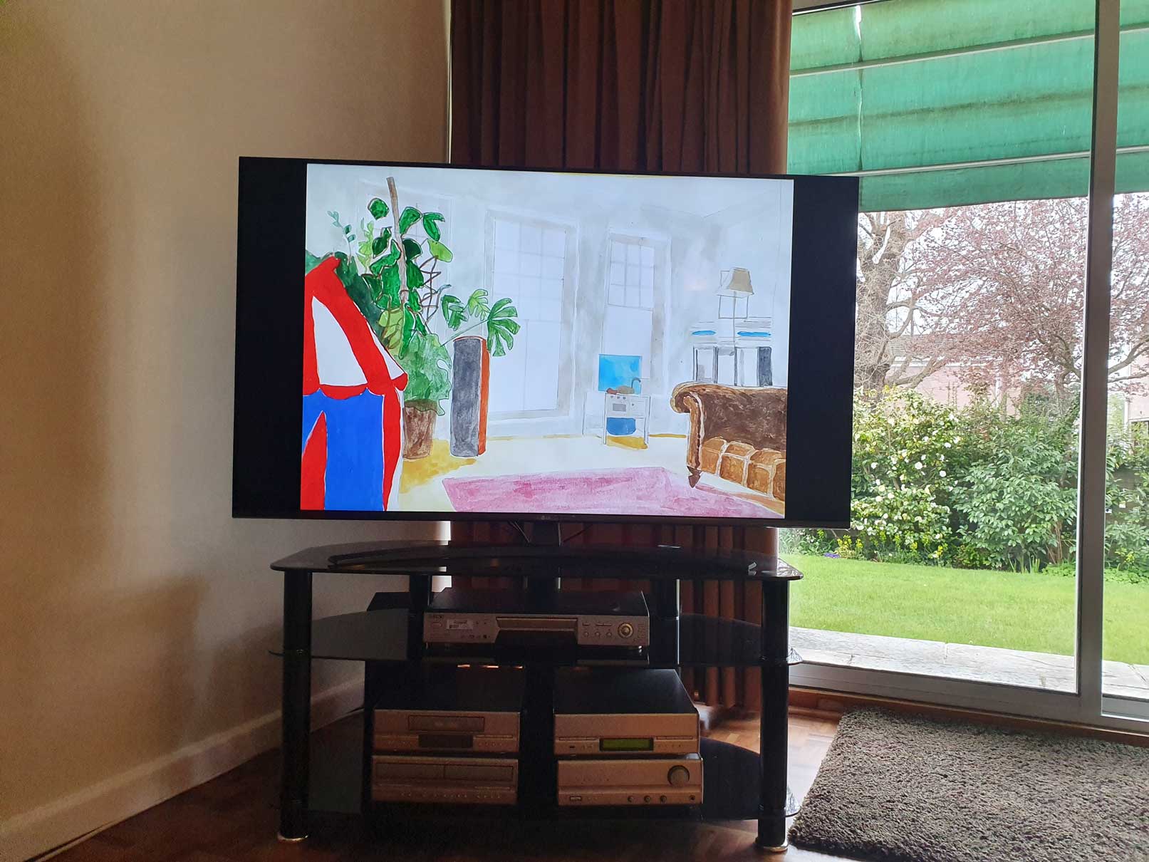 An image of a painting by the artist Alice Mendelowitz is displayed on a TV in the corner of a room, next to a glass sliding door that leads to a garden.