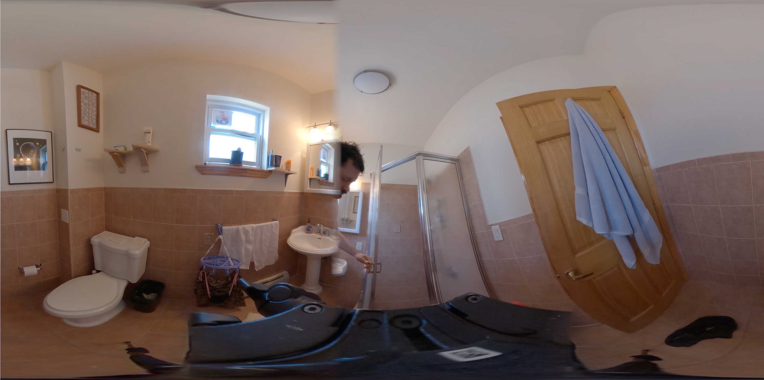 a still image from a 360 degree video of the artist in his bathroom